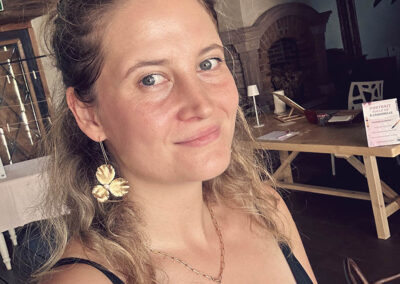 Selfie de l’illustratrice Emeline Lombrez devant son stand de live drawing lors d’un mariage au Château de Thanvillé en Alsace, proche de la Suisse.
